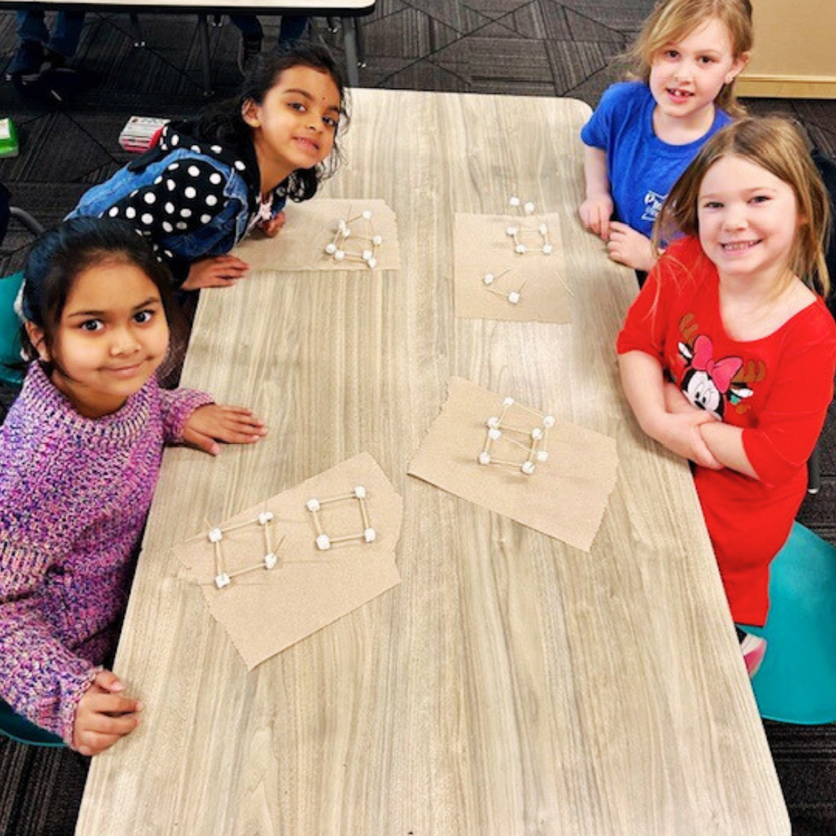Students show off their 3D models made with marshmallows and noodles.