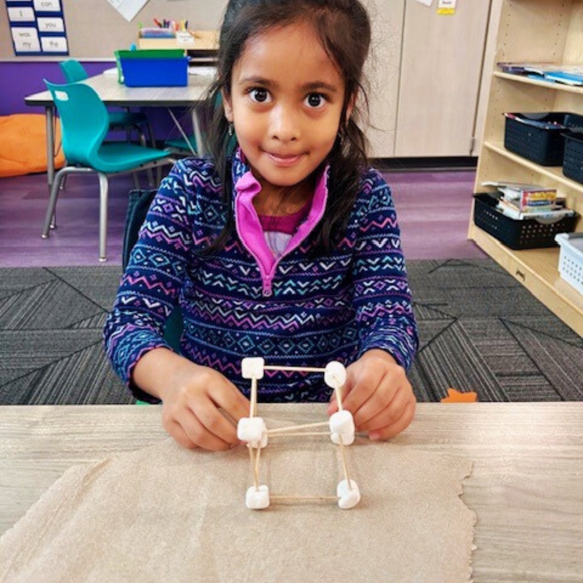 Students show off their 3D models made with marshmallows and noodles.