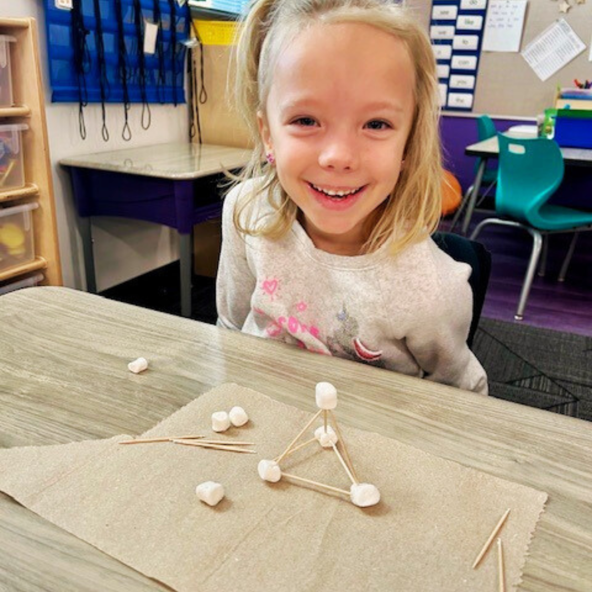 Students show off their 3D models made with marshmallows and noodles.