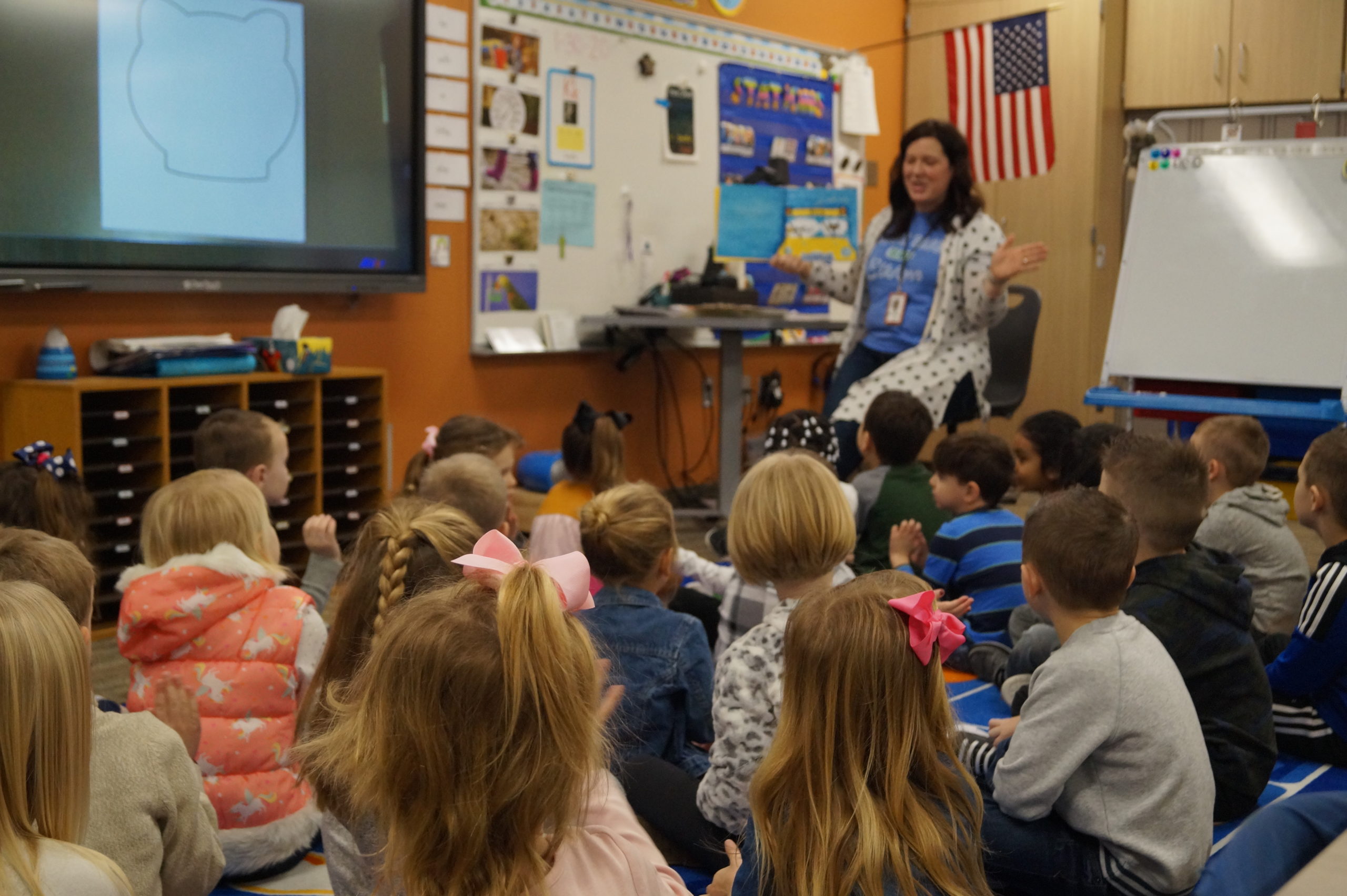 A teacher reads a book to students