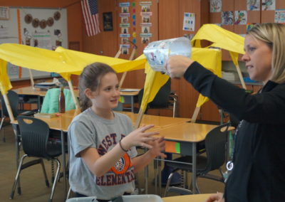 A teacher does a quick check of a studen't wagon prior to setting it afloat.