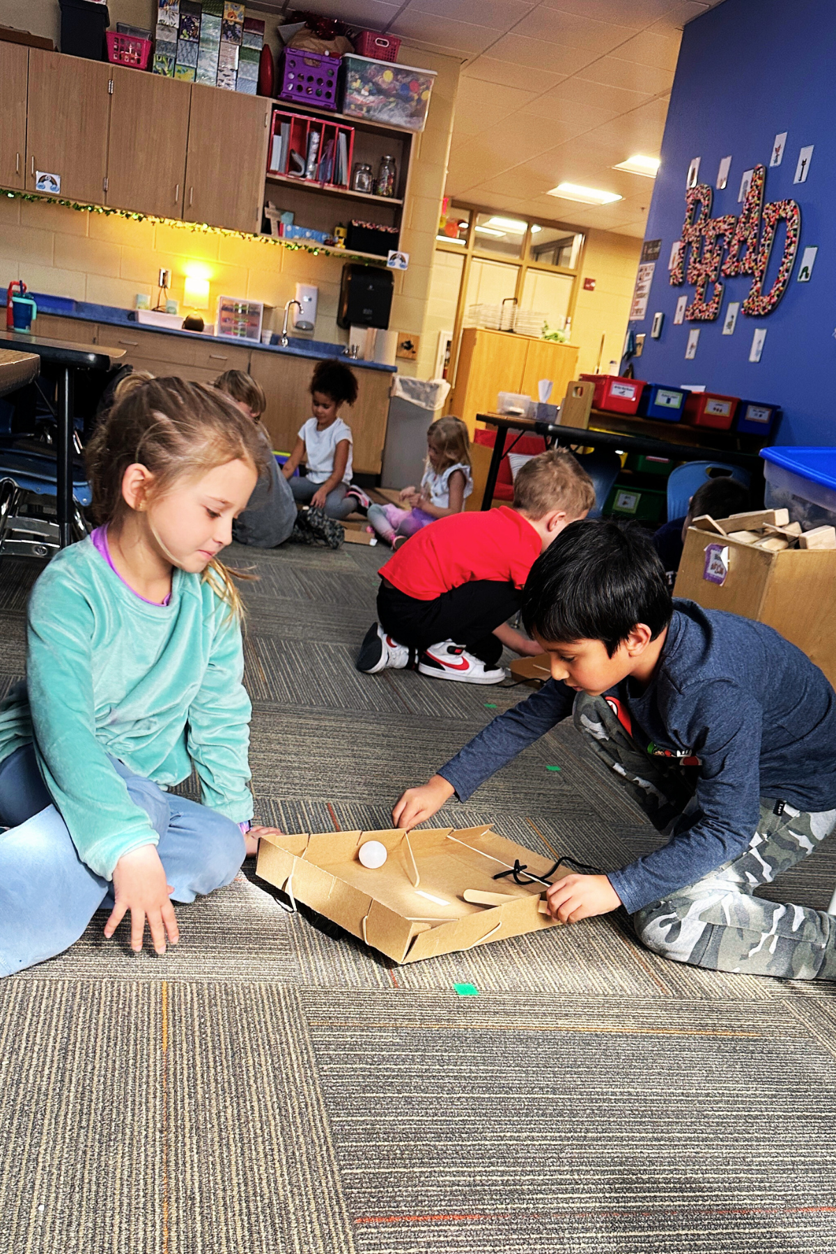 Students use a homemade pinball machine to learn about force.