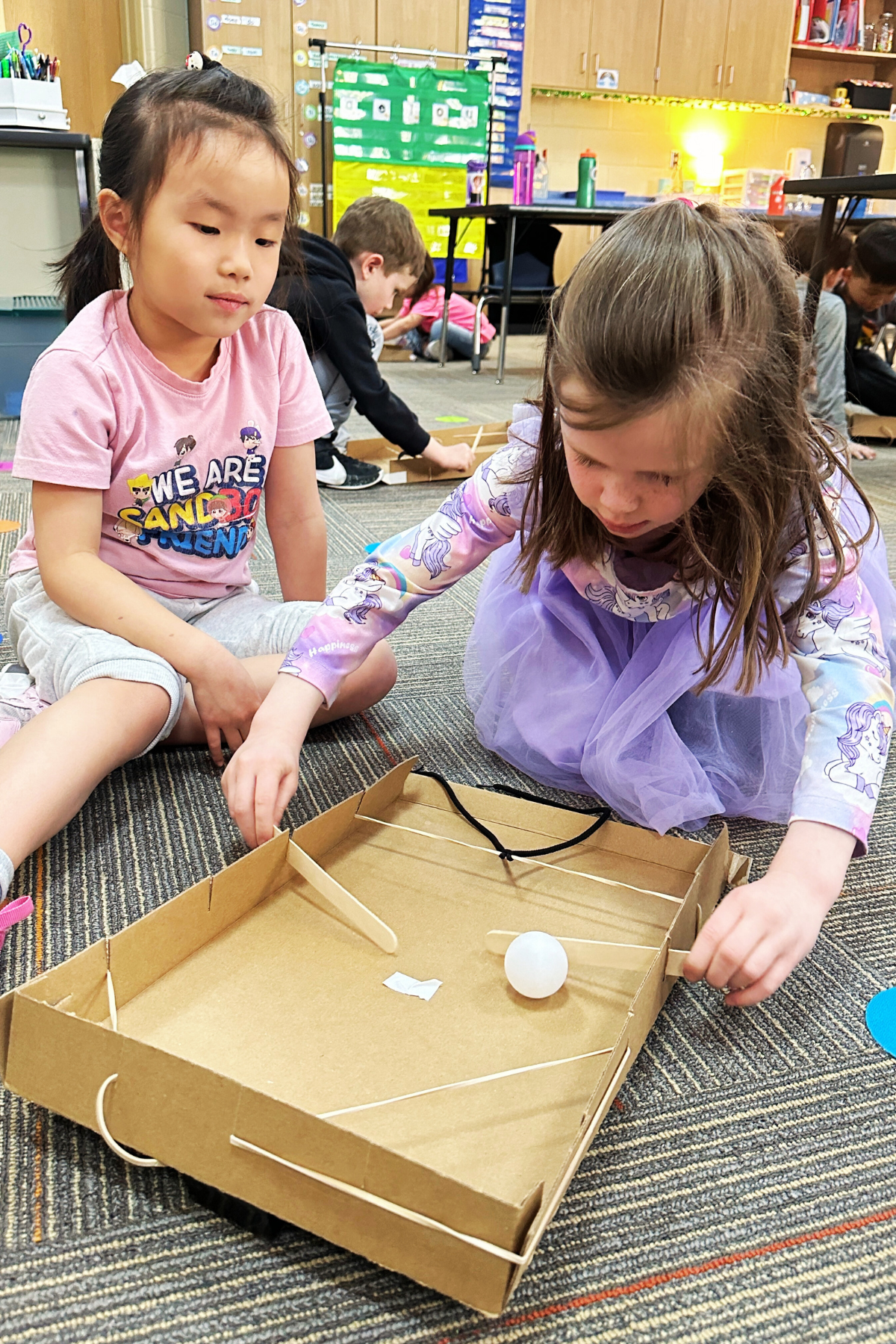 Students use a homemade pinball machine to learn about force.